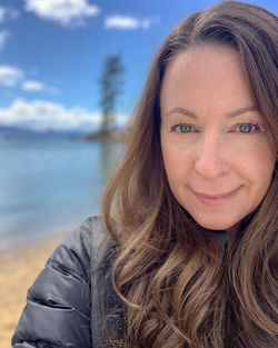 Portrait of beautiful woman against lake