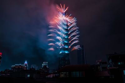 Low angle view of firework display at night