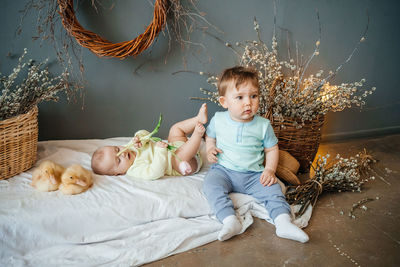 Two babies with small goslings eco style grey background wicker basket willow