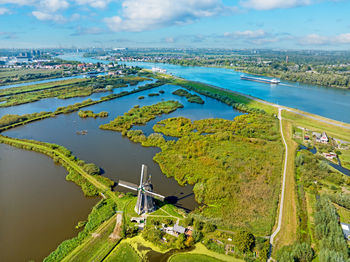 High angle view of city by sea against sky