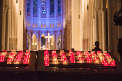 Illuminated candles in temple outside building