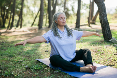 Portrait of young woman exercising in forest