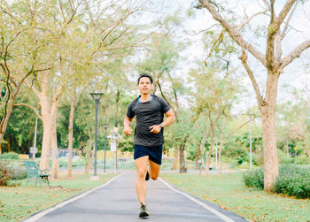 Full length of man running on footpath