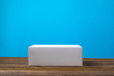 Close-up of white table against blue wall