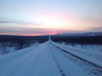 Snow covered landscape at sunset