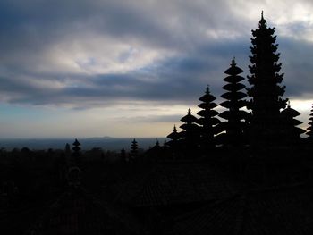 Silhouette of temple against cloudy sky