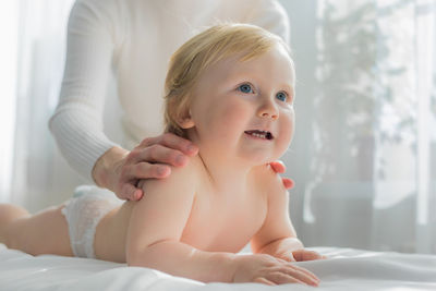 Mom gives her baby a shoulder and back massage. close-up.