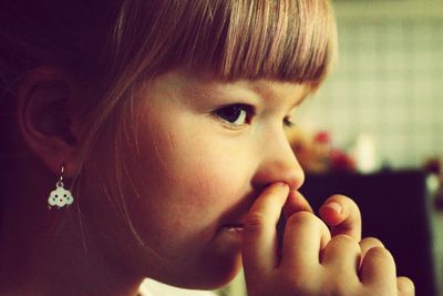 Close-up of girl with finger in nose at home