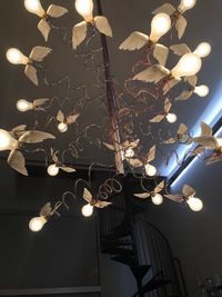 Low angle view of illuminated pendant lights hanging from ceiling