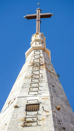 Low angle view of cross against clear blue sky