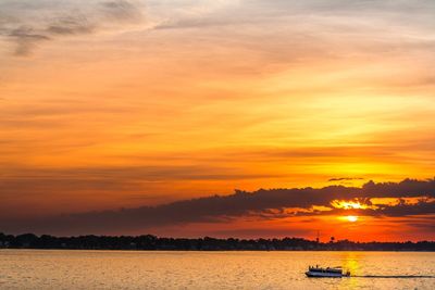 Ferry sailing in river at sunset