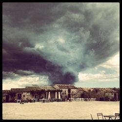 Built structures against cloudy sky