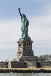 Low angle view of statue of liberty against sky