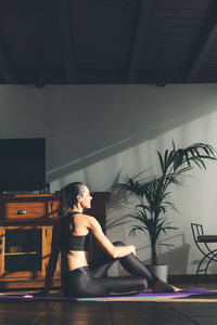 Young caucasian brunette woman stretching at home. vertical format.