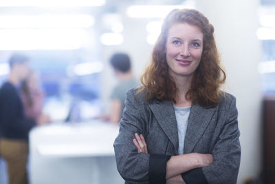 Employee in an office standing with crossed arms