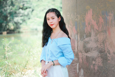 Portrait of beautiful woman standing against wall