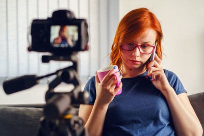 Young woman photographing with mobile phone