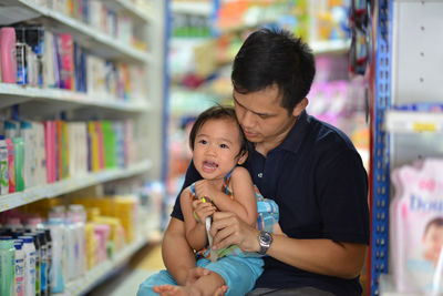 Close-up of father holding cute daughter at store