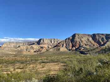 Scenic view of mountain against blue sky