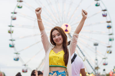 Portrait of young woman standing in amusement park