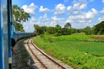 Railroad track against cloudy sky