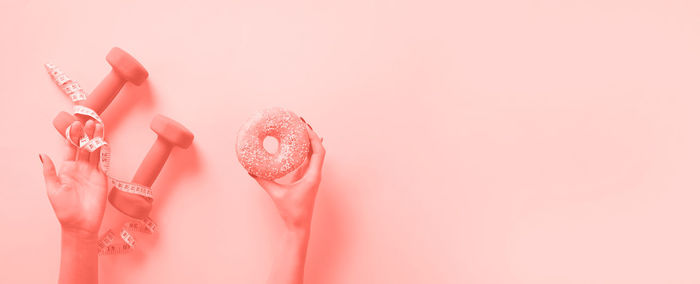 Close-up of woman against pink wall