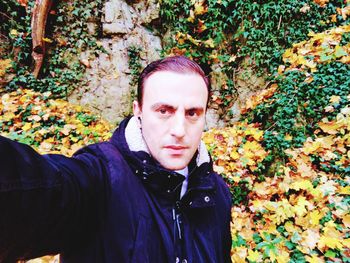 Portrait of teenage boy with autumn leaves