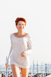 Portrait of smiling woman standing against sky