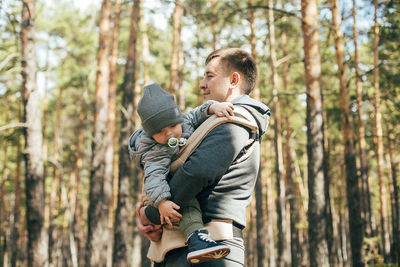 Rear view of father and son in forest