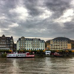 Buildings in city against cloudy sky