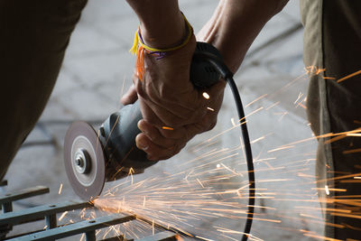 Midsection of welder welding metal in factory