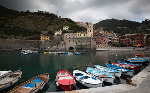 Boats moored in canal by buildings in city