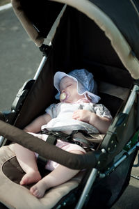 High angle view of baby girl lying in baby carriage