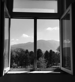 Trees and mountains seen through window