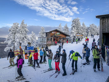 People on snow covered mountain against sky