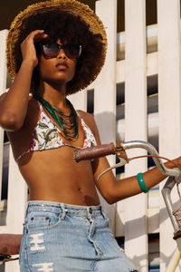 Young black woman at the beach with her bicycle