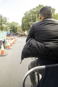 Rear view of man sitting on street