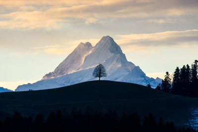 Scenic view of snowcapped mountains against sky during sunset