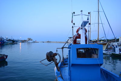 Ship moored at harbor against clear sky