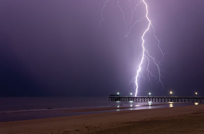 Lightning over sea against sky at night