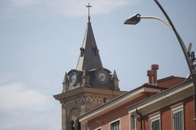 Low angle view of street light by building against sky