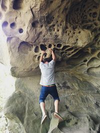 Full length of man hanging on rock formation