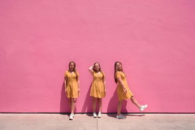 High angle view of women standing against pink wall