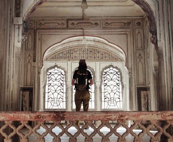 Rear view of man standing against door of building