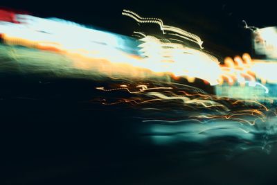 Light trails in city against sky at night