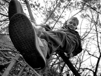 Low angle view of child on bare tree