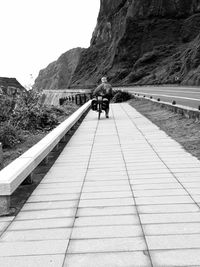 Rear view of man walking on footpath