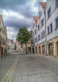 Buildings in city against cloudy sky