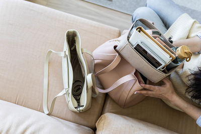 Low section of woman using mobile phone while lying on bed