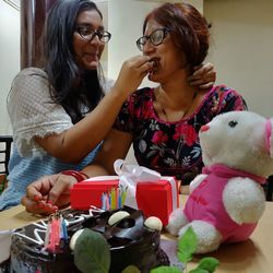 Portrait of happy woman holding eyeglasses at home
